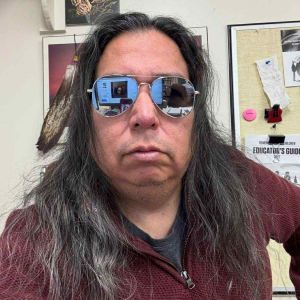 Image of Bill Stevenson wearing sunglasses and a wine colored sweater.